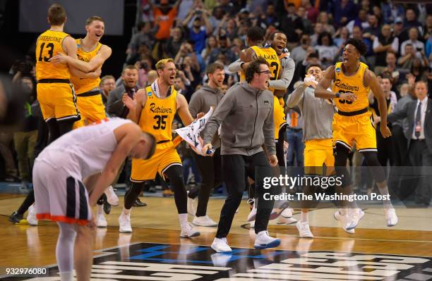 Charlotte NC Virginia guard Kyle Guy , left, reacts to UMBC celebrating as UMBC upsets the University of Virginia in the 1st round for the mens NCAA...