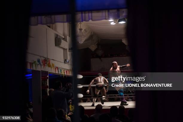 Wrestlers are pictured during a show on March 11 in Nanterre, near Paris. In Nanterre, the French Association of Professional Wrestling revives...