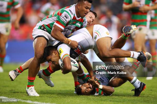Tyrone Peachey of the Panthers breaking the tackle of Richard Kennar and Alex Johnston of the Rabbitohs on his way to score a try during the round...