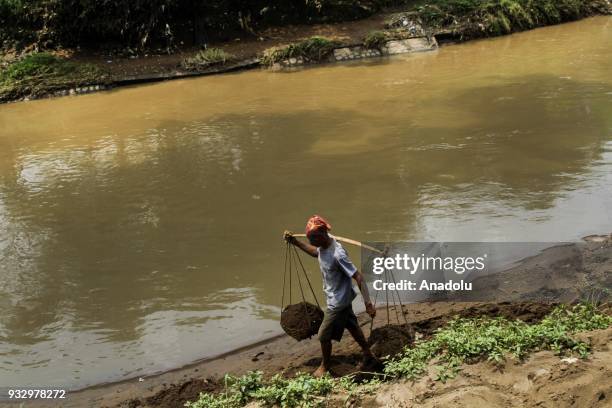 Residents seek sand on the banks of the Citarum river in the village of Parigi, Ciparay, Bandung, West Java, Indonesia, on March 16, 2018. Total of...