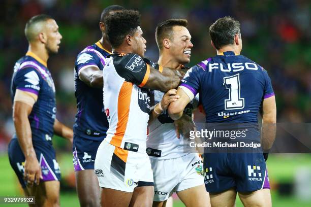Billy Slater of the Storm is hassled by Luke Brooks of the Tigers during the round two NRL match between the Melbourne Storm and the Wests Tigers at...