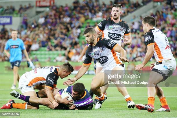 Kenny Bromwich of the Storm is tackled by Luke Brooks of the Tigers during the round two NRL match between the Melbourne Storm and the Wests Tigers...