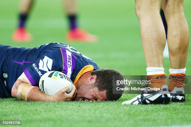 Kenny Bromwich of the Storm reacts in pain after being tackled by Luke Brooks of the Tigers during the round two NRL match between the Melbourne...