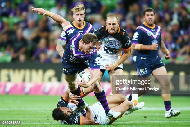 Tim Glasby of the Storm gets tackled during the round two NRL match between the Melbourne Storm and the Wests Tigers at AAMI Park on March 17, 2018...