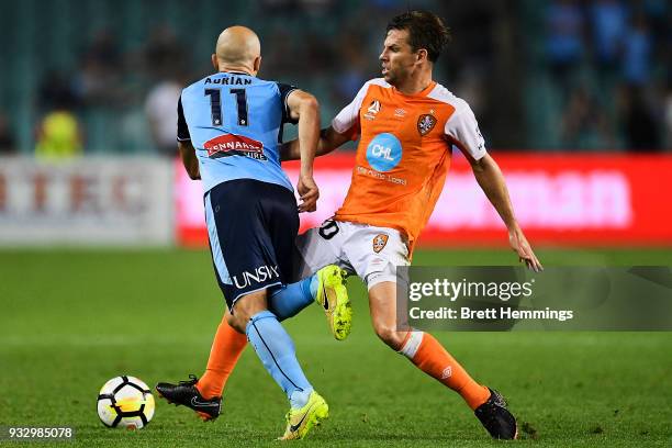 Adrian Mierzejewski of Sydney is tackled by Brett Holman of Brisbane during the round 23 A-League match between Sydney FC and the Brisbane Roar at...