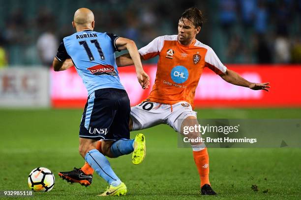 Adrian Mierzejewski of Sydney is tackled by Brett Holman of Brisbane during the round 23 A-League match between Sydney FC and the Brisbane Roar at...