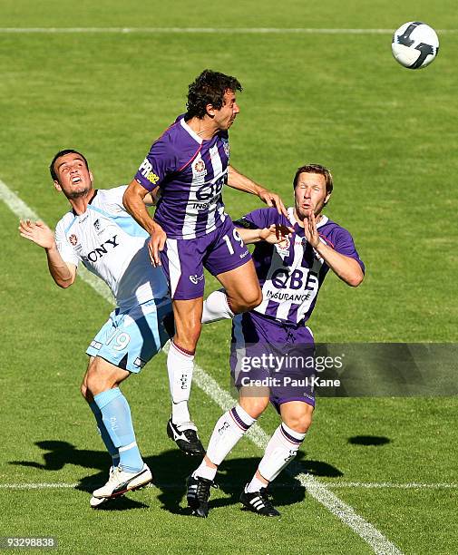 Naum Sekulovski of the Glory heads the ball away from team mate Andy Todd and Mark Bridge of Sydney during the round 15 A-League match between Perth...