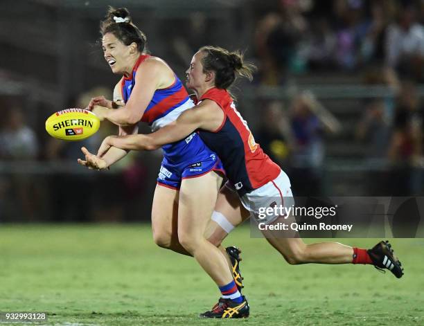 Emma Kearney of the Bulldogs handballs whilst being tackled by Daisy Pearce of the Demons during the round seven AFLW match between the Western...