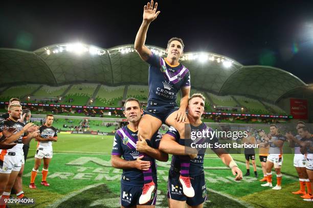 Billy Slater of the Melbourne Storm is chaired off by teammates Cameron Smith of the Melbourne Storm and Ryan Hoffman of the Melbourne Storm after...