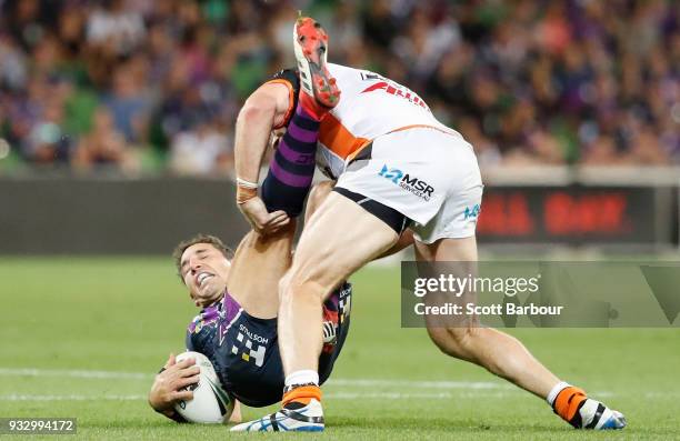 Billy Slater of the Melbourne Storm is tackled during the round two NRL match between the Melbourne Storm and the Wests Tigers at AAMI Park on March...