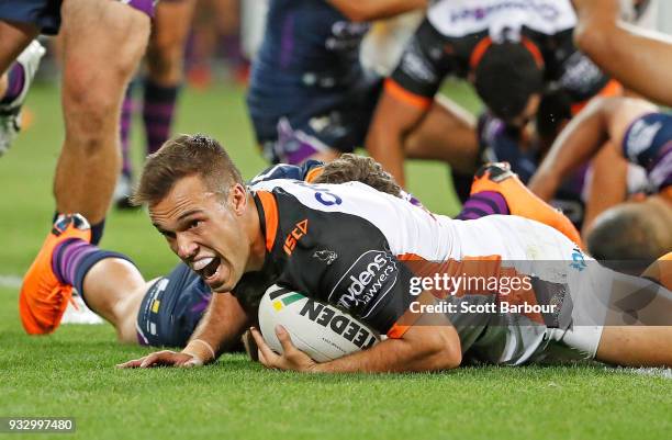 Luke Brooks of the Tigers scores the winning try during the round two NRL match between the Melbourne Storm and the Wests Tigers at AAMI Park on...