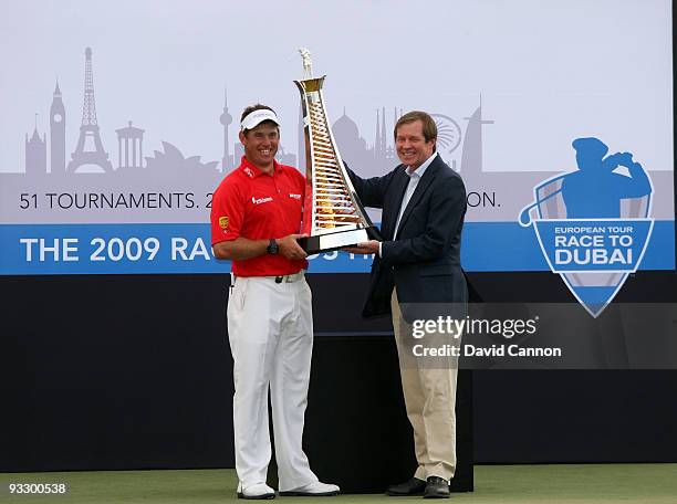 Lee Westwood of England is presented with the Race to Dubai Trophy by George O'Grady the Chief executive of the European Tour after his victory in...