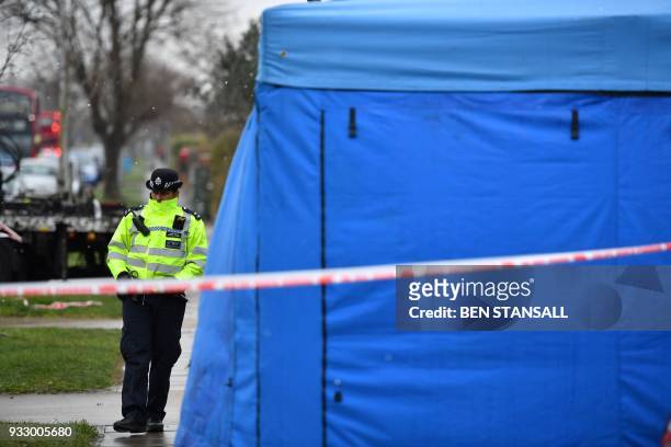 Police officer stands at the cordon by a forensics tent in front of the home of slain Russian exile Nikolai Glushkov in southwest London on March 17,...