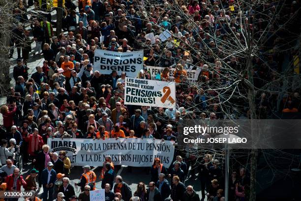 Pensioners hold up banners as they march in Barcelona on March 17 during a protest called by 'Marea Pensionista' and supported by the main Spanish...