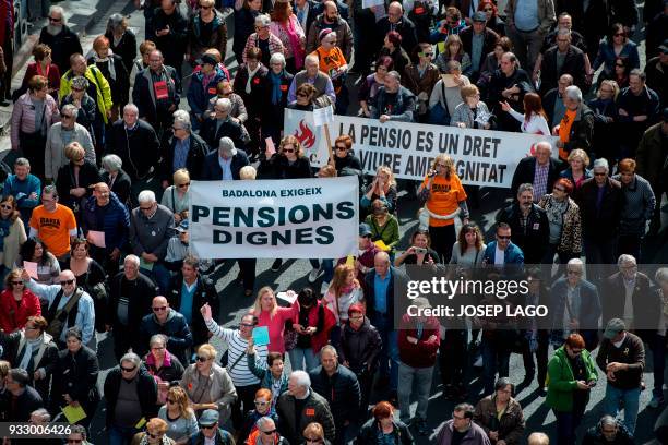 Pensioners hold up banners as they march in Barcelona on March 17 during a protest called by 'Marea Pensionista' and supported by the main Spanish...