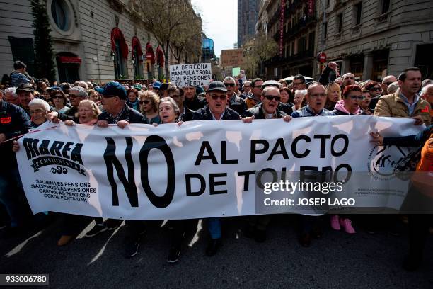 Pensioners march behind a banner with the slogan "No to Toledo's pact" in Barcelona on March 17 during a protest called by 'Marea Pensionista' and...