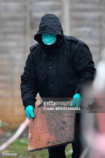 Police officer works at the rear of the home where Russian exile Nikolai Glushkov lived in southwest London on March 17, 2018 after they launched a...