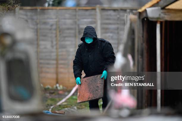 Police officer works at the rear of the home where Russian exile Nikolai Glushkov lived in southwest London on March 17, 2018 after they launched a...