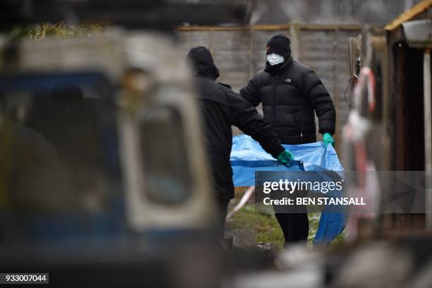 Police officers work at the rear of the home where Russian exile Nikolai Glushkov lived in southwest London on March 17, 2018 after they launched a...