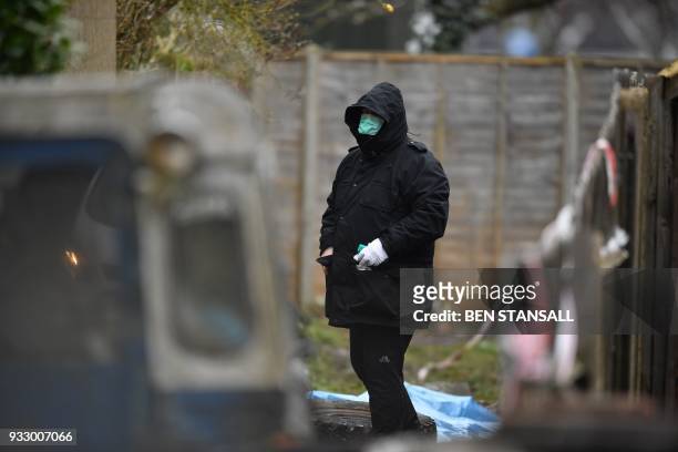 Police officer works at the rear of the home where Russian exile Nikolai Glushkov lived in southwest London on March 17, 2018 after they launched a...