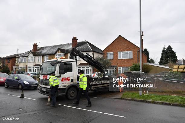 Vehicle recovery workers remove a vehicle from a driveway leading to the rear of the home where Russian exile Nikolai Glushkov lived in southwest...