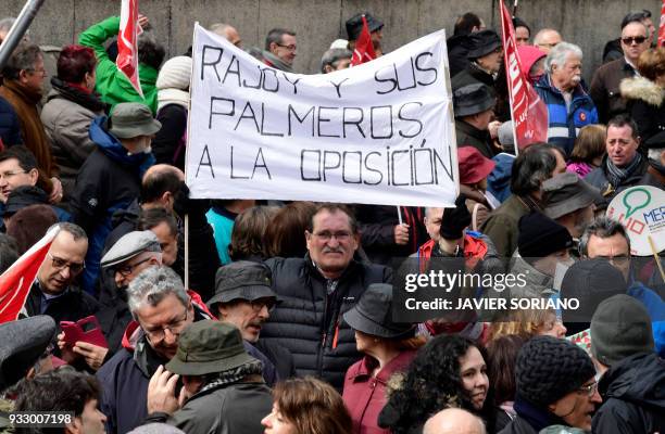 Demonstrator holds up a banner reading "Rajoy and his clappers, to the opposition" in Madrid on March 17 during a protest called by the main Spanish...