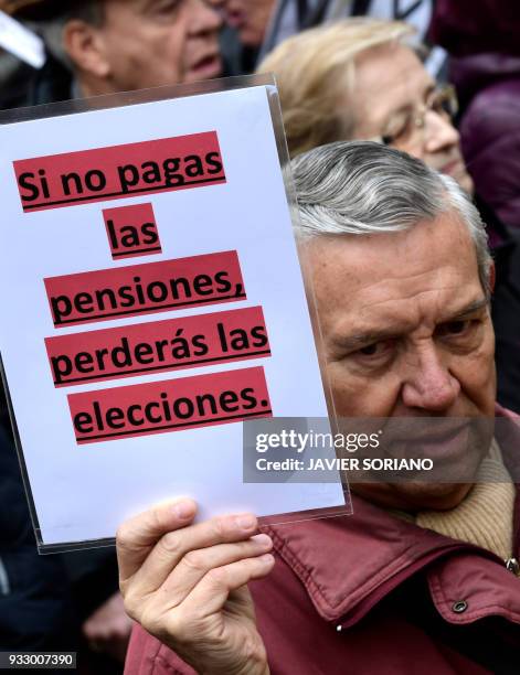Demonstrator holds up a poster reading "I you don't pay pensions, you will lose election" in Madrid on March 17 during a protest called by the main...