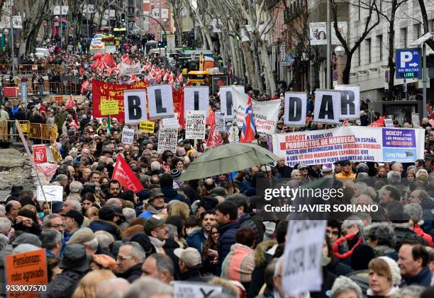 Demonstrators hold up big letters reading "SAFEGUARD" in Madrid on March 17 during a protest called by the main Spanish unions and the 'State...