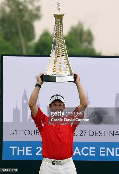 Lee Westwood of England raises the Race to Dubai Trophy after his victory in the final round of the Dubai World Championship, on the Earth Course,...
