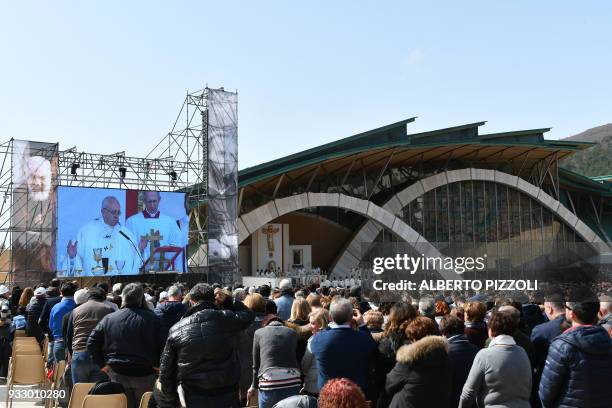 Pope Francis is seen on a giant screen during a mass in San Giovanni Rotondo on March 17, 2018 as part of a pastoral visit on the 50th anniversary of...