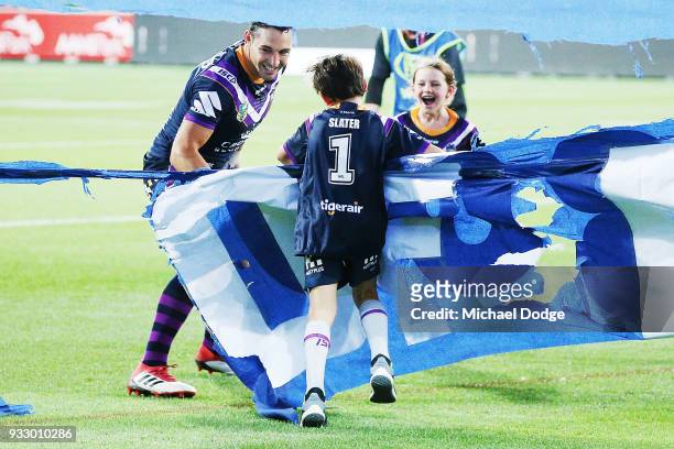 Billy Slater runs out through the banner with hisÊÊtwo children, daughter Tyla Rose and son Jake, for this 300th match during the round two NRL match...