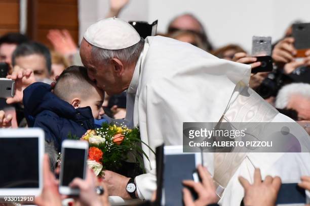 Pope Francis kisses a child in San Giovanni Rotondo on March 17, 2018 during a pastoral visit on the 50th anniversary of the death of St Pio . Pio...