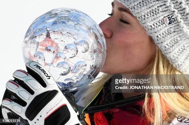 Mikaela Shiffrin of the US kisses the crystal globe trophy after winning the overall World Cup and also the Women's Slalom event of the Alpine Skiing...