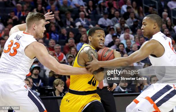 Teammates Jack Salt and Devon Hall of the Virginia Cavaliers try to stop Jairus Lyles of the UMBC Retrievers during the first round of the 2018 NCAA...