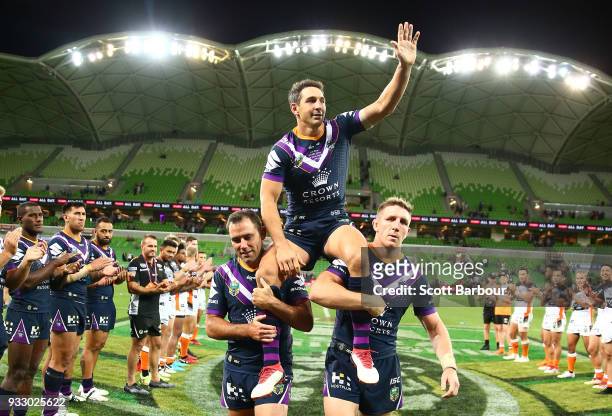Billy Slater of the Melbourne Storm is chaired off by teammates Cameron Smith of the Melbourne Storm and Ryan Hoffman of the Melbourne Storm after...