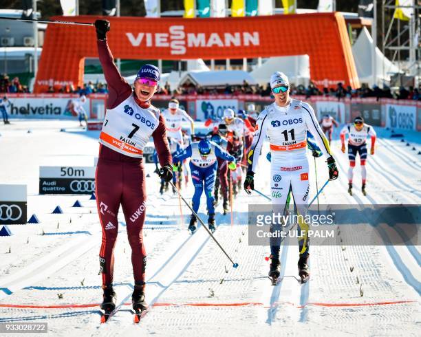 Alexander Bolshunov of Russia reacts after crossing the finish line to win ahead of Sweden's Calle Halfvarsson and Francesco de Fabiani of Italy of...