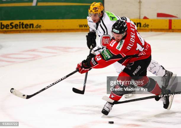 Daniel Rudslaett of Haie shoots on goal as Michael Bresagk of Lions defends during the Deutsche Eishockey Liga game between Koelner Haie and...