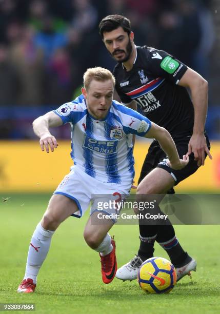 James Tomkins of Crystal Palace puts pressure on Alex Pritchard of Huddersfield Town during the Premier League match between Huddersfield Town and...