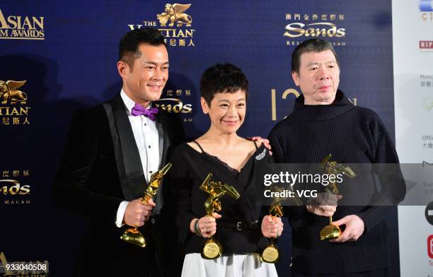 Actor Louis Koo, actress Sylvia Chang and director Feng Xiaogang pose with trophies at backstage during the 12th Asian Film Awards at the Venetian...