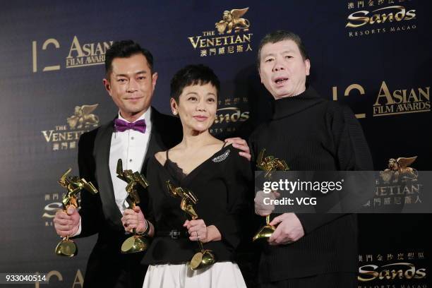 Actor Louis Koo, actress Sylvia Chang and director Feng Xiaogang pose with trophies at backstage during the 12th Asian Film Awards at the Venetian...