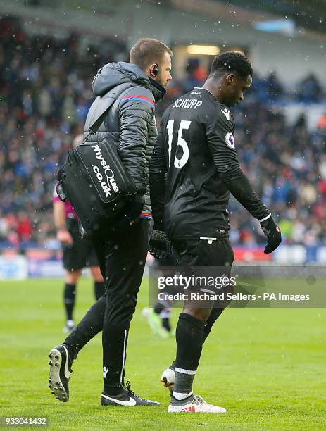 Crystal Palace's Jeffrey Schlupp leaves the pitch with medical staff during the Premier League match at the John Smith's Stadium, Huddersfield.