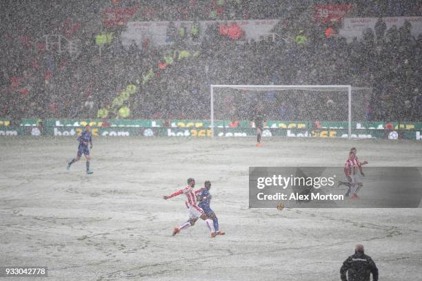 General view inside the stadium as snow falls during the Premier League match between Stoke City and Everton at Bet365 Stadium on March 17, 2018 in...