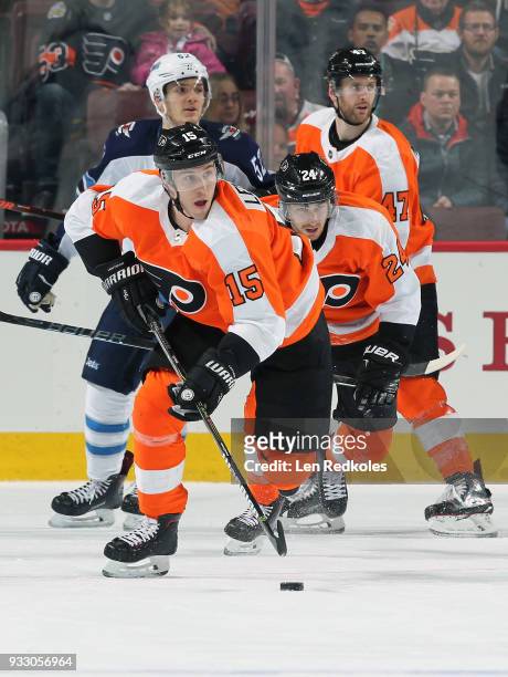 Jori Lehtera of the Philadelphia Flyers skates the puck with Matt Read and Andrew MacDonald against Jack Roslovic of the Winnipeg Jets on March 10,...
