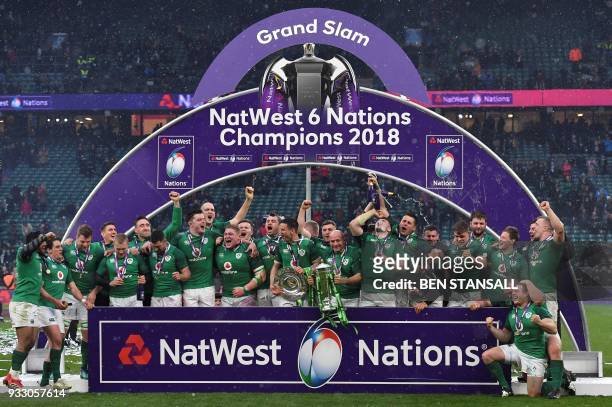 Ireland's hooker Rory Best holds the Six Nations trophy and Ireland's fly-half Jonathan Sexton the Triple Crown as Ireland players celebrate their...