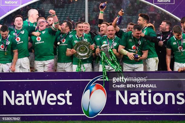 Ireland's hooker Rory Best holds the Six Nations trophy and Ireland's fly-half Jonathan Sexton the Triple Crown as Ireland players celebrate their...