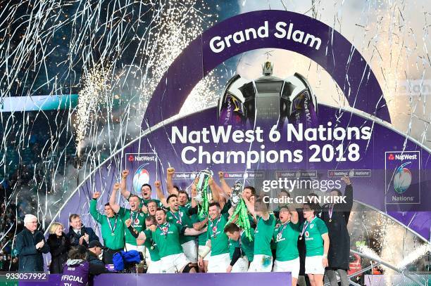 Ireland's hooker Rory Best holds the Six Nations trophy and Ireland's fly-half Jonathan Sexton the Triple Crown as Ireland players celebrate their...