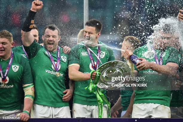 Ireland's fly-half Jonathan Sexton hold the Triple Crown as he is sprayed with champagn as Ireland players celebrate their Six Nations Grand Slam...