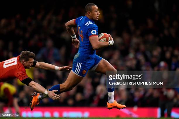 France's wing Gael Fickou evades the tackle of Wales' fly-half Dan Biggar during the Six Nations international rugby union match between Wales and...