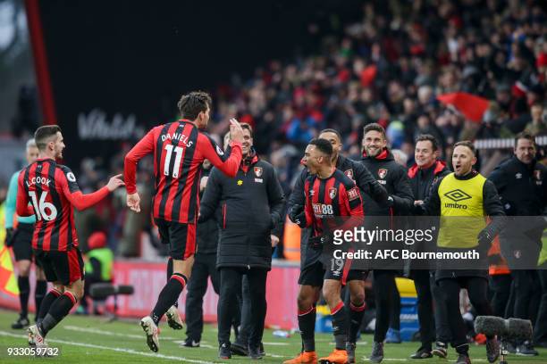 Junior Stanislas of Bournemouth is congratulated by team-mates Lewis Cook and Charlie Daniels after he scores the winning goal to make it 2-1 during...