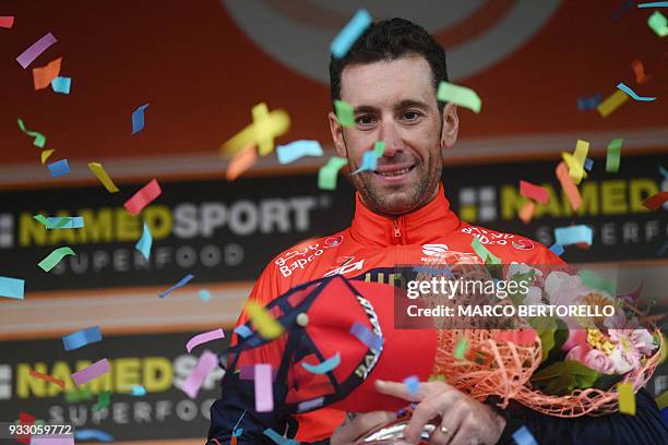 Italy's Vincenzo Nibali of team Bahrain celebrates on the podium after winning the 109th edition of the Milan - San Remo cycling race on March 17,...